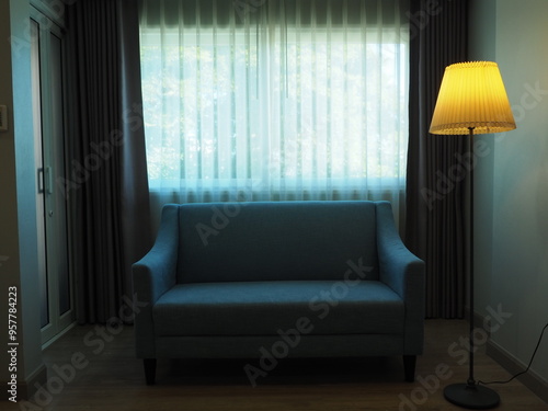 modern living room with sofa. Background of comfortable and cozy sofa with beautiful lamp and window with light white curtain. Horror and sad scene concept.