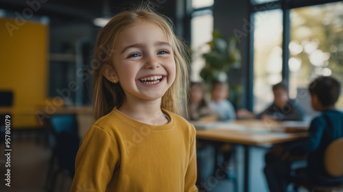 Happy child girl standing and laughing while a group of child boys colleagues are sitting at a table in a conference room