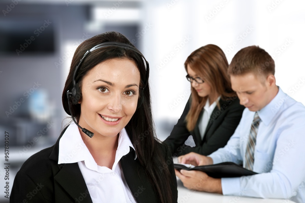 © BillionPhotos.com - Smiling business person with headset working in a call center