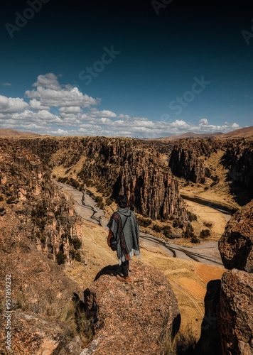 Andean man standing looking at canyons