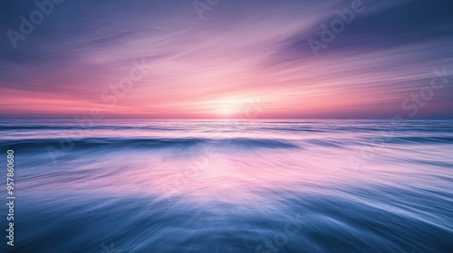 A serene ocean at dawn with the sky transitioning from dark to light, soft pinks and purples reflected on the water's surface