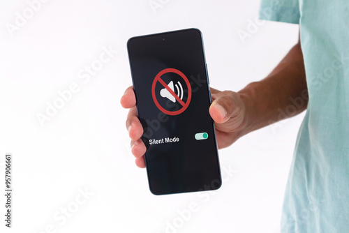 Man holding a smartphone with mute sound or silent mode symbol on the screen