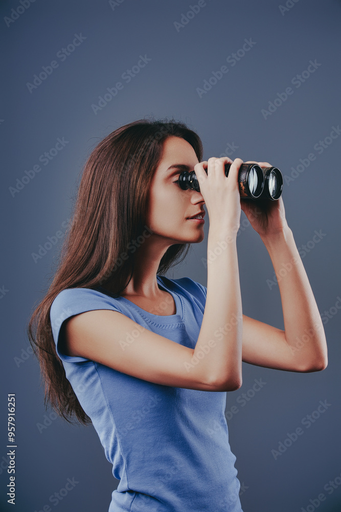 Young woman looking through binoculars exploring future opportun Young woman looking through binoculars exploring future opportun