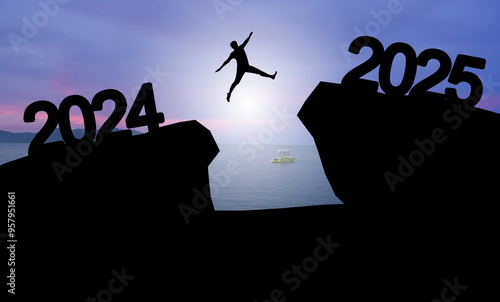 Happy new year 2025 Silhouette image of happy man jump from 2024 up to 2025 on sunset background.