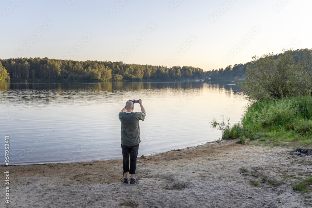 Fototapeta premium A man is taking a picture of the lake