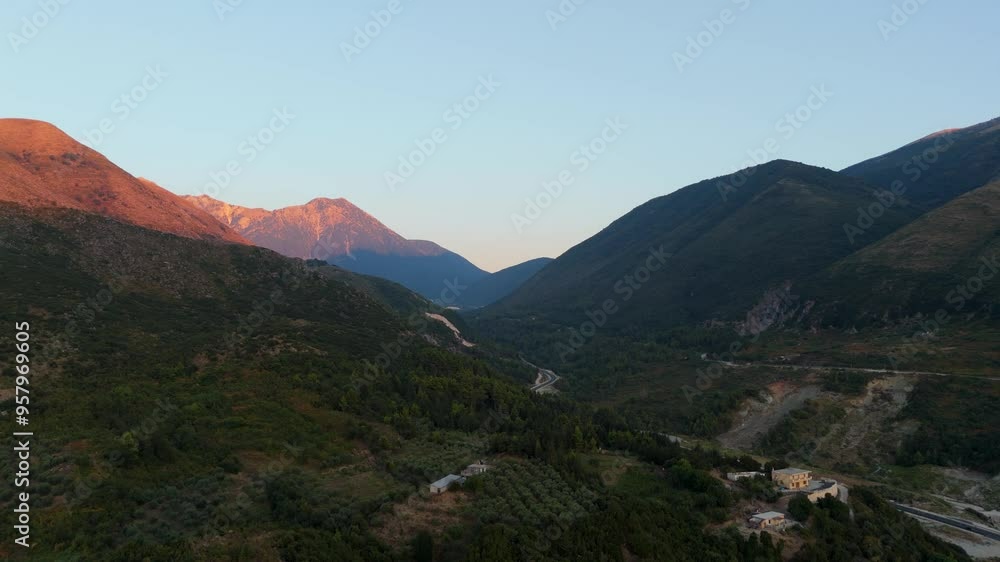Sunset over a serene mountainous landscape with valleys and lush green vegetation Sunset over a serene mountainous landscape with valleys and lush green vegetation