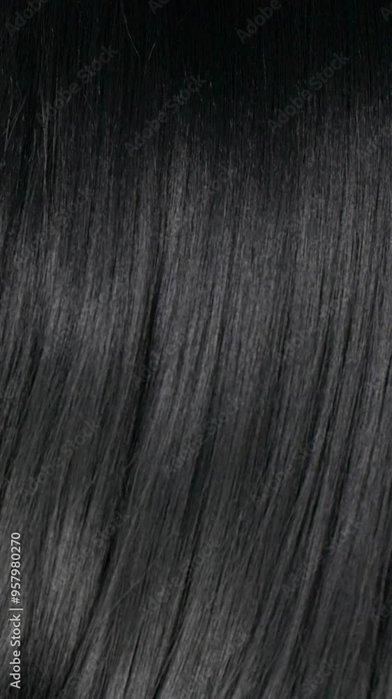 Vertical female long hair texture in slow motion, black straight hair background Vertical female long hair texture in slow motion, black straight hair background