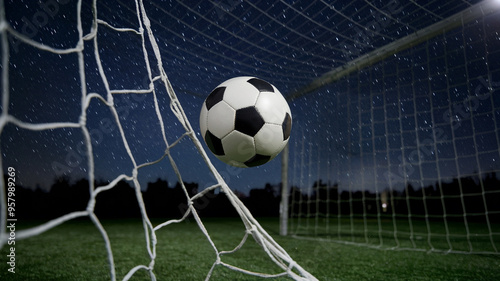 Soccer ball hitting the net under the night sky, illuminated by stadium lights, depicting a dramatic goal moment in football.