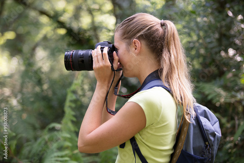 female photographer focusing camera in the countryside