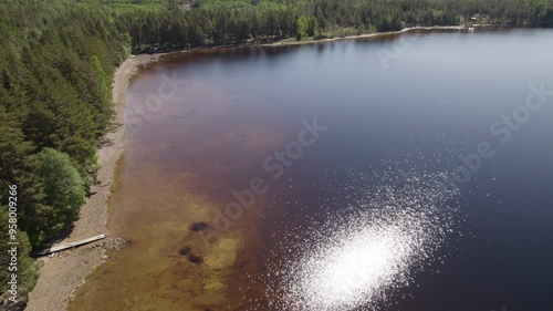 Drone footage of a glimmering lake in the woods. photo