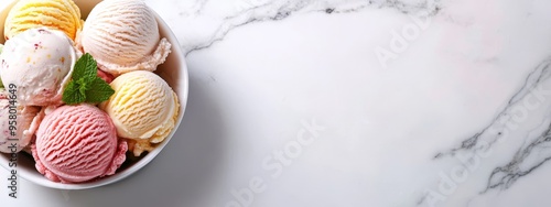  A marble countertop holds a bowl brimming with various hued ice creams, accompanied by an individual cup of ice cream photo