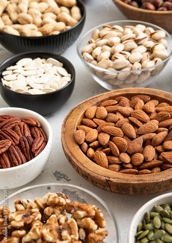 Mixed raw nuts and seeds in bowls on kitchen table.Peanut,hazelnut,walnut,almonds,pistachio,sunflower,pumpkin,chia and cashew.Macro