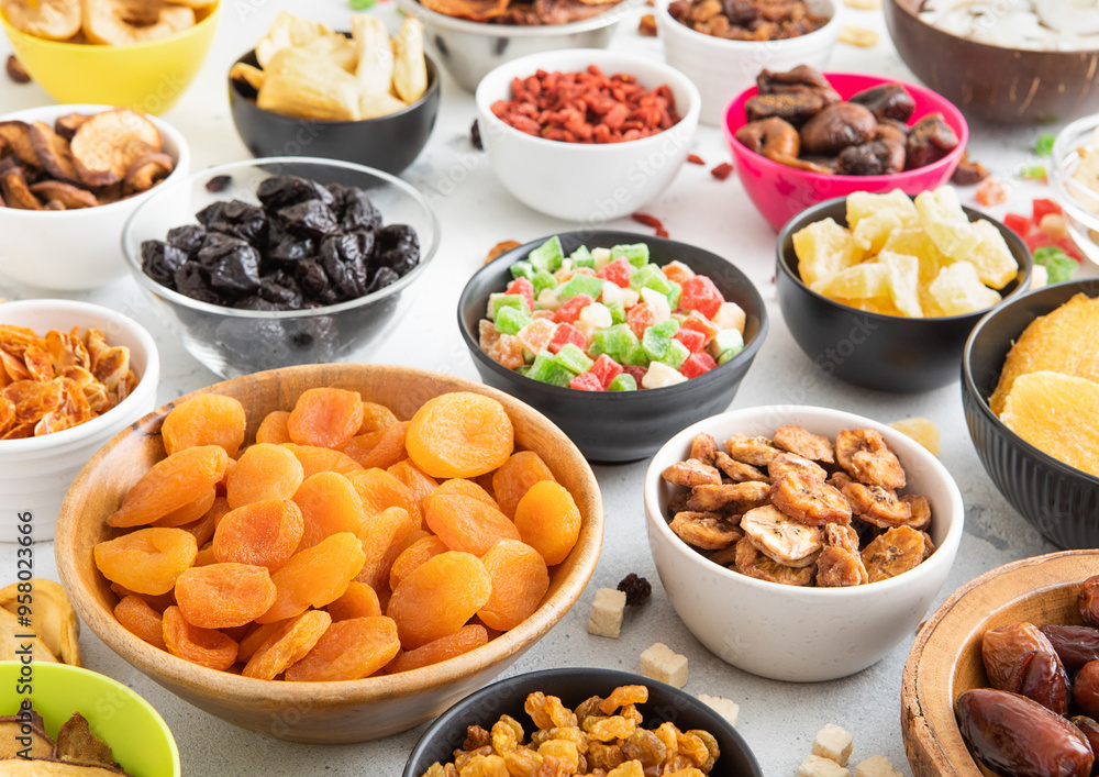 Mix of healthy dried sweet fruits and berries in various bowl plates on light kitchen background.Macro. Mix of healthy dried sweet fruits and berries in various bowl plates on light kitchen background.Macro.