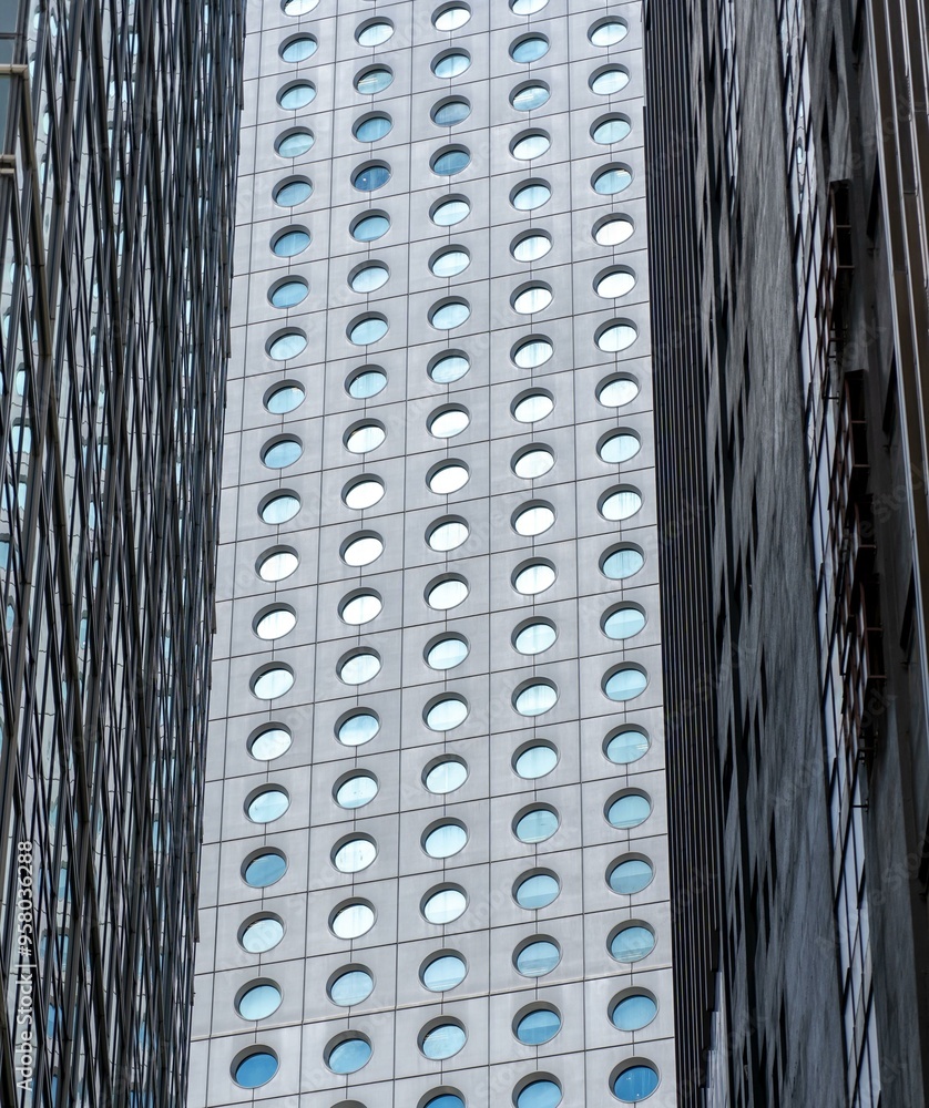 A close-up view of three tall buildings in Hong Kong, China, with contrasting window patterns. A close-up view of three tall buildings in Hong Kong, China, with contrasting window patterns.