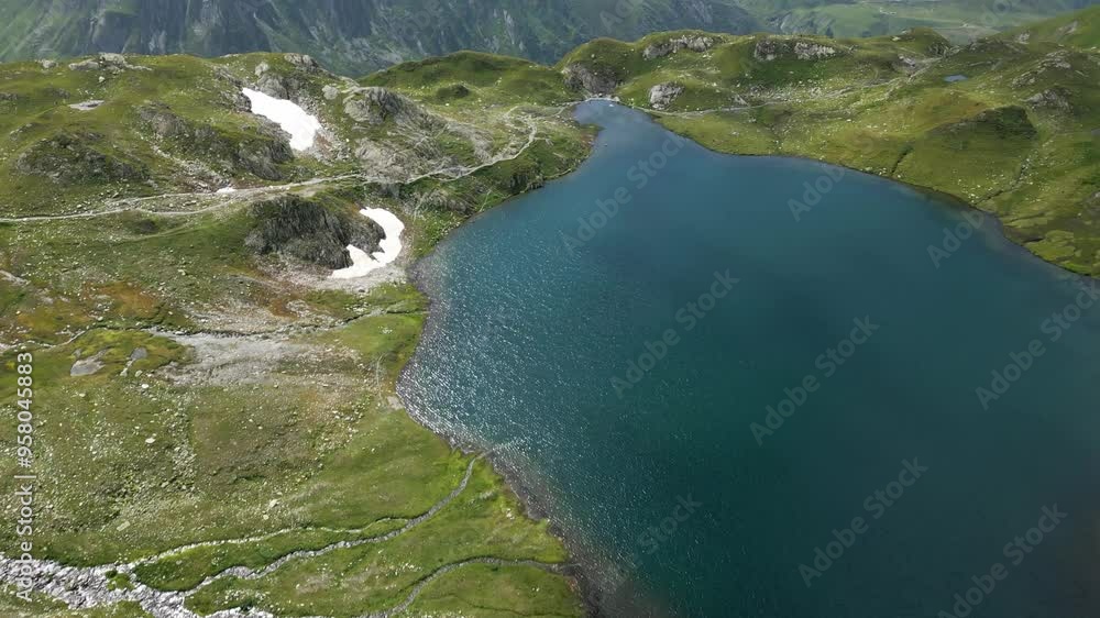 Reveal drone shot of a lake above the mountain in the Swiss Alps. Reveal drone shot of a lake above the mountain in the Swiss Alps.