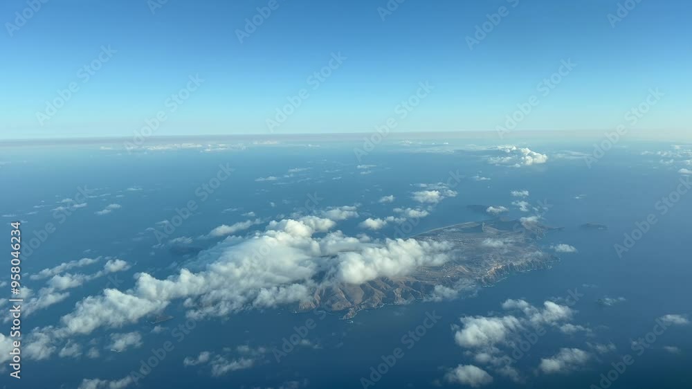 Aerial view of Porto Santo Island (Portugal). Aerial footage taken from an airplane cockpit flying bound to Madeira. The island and airport runway is partially covered by some low clouds. Daylight 4K Aerial view of Porto Santo Island (Portugal). Aerial footage taken from an airplane cockpit flying bound to Madeira. The island and airport runway is partially covered by some low clouds. Daylight 4K