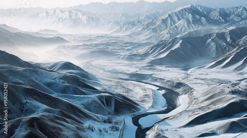 Qilian Mountains in winter, with smooth, snow-covered textures, winding rivers, and soft morning light breaking through the mist, creating tranquility photo