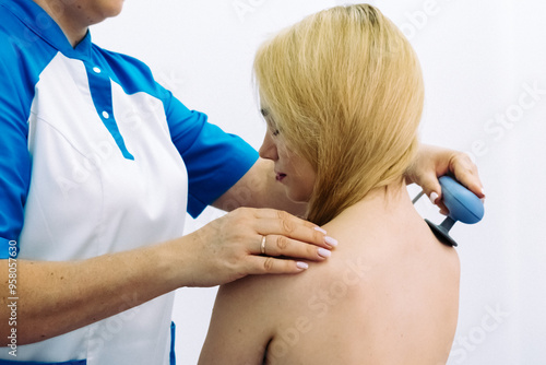 A doctor administers magnetic therapy to a young woman, targeting muscle recovery post-injury. Ideal for showcasing advanced physiotherapy treatments that accelerate healing and restore function.