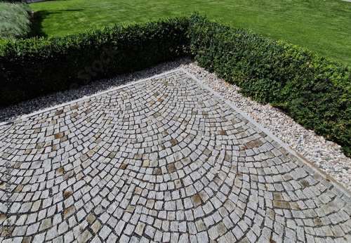 cut squares of flowerbed edging in a historic garden made of boxwood hedges. courtyard of castle along cobblestone path row of squares frozen ice, snowing  evergreen topiary, ivy, creeper, above, top photo