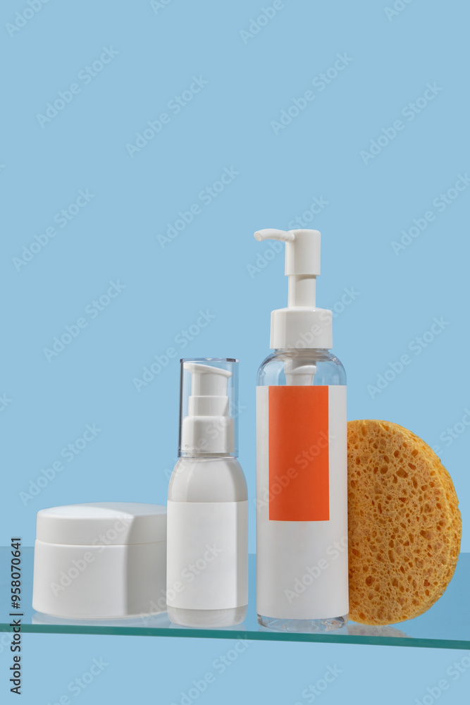 Set of cosmetic products. Face wash and cleanser, moisturizer, face serum stand on glass shelf in bathroom against light blue wall. Moisturizing and cleansing concept. Set of accessories for hygiene. Set of cosmetic products. Face wash and cleanser, moisturizer, face serum stand on glass shelf in bathroom against light blue wall. Moisturizing and cleansing concept. Set of accessories for hygiene.