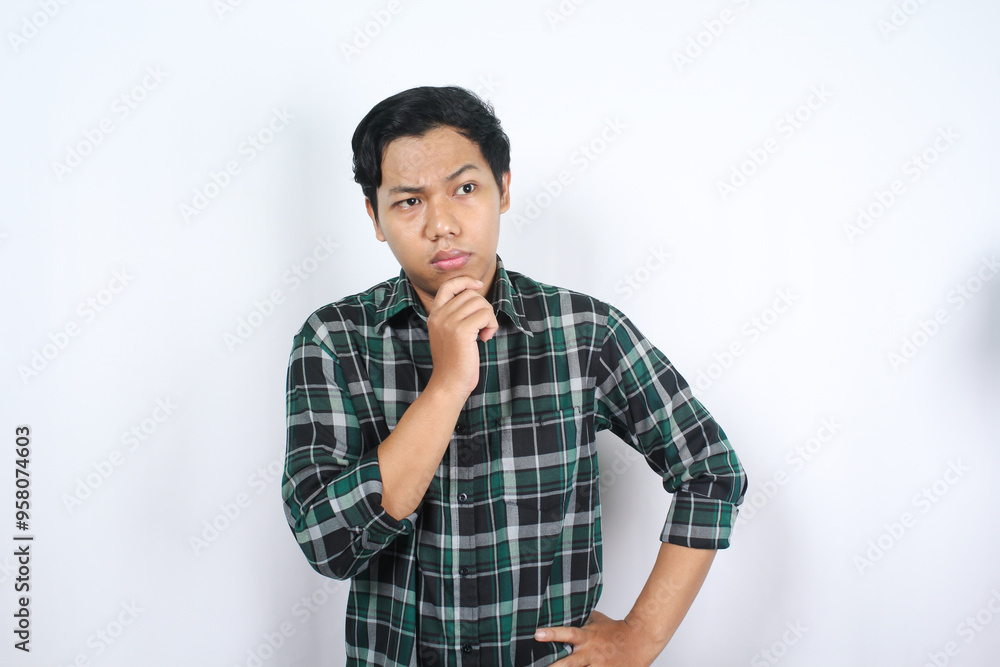 thoughtful smart asian young man wearing casual clothes making decision with hand on chin isolated thoughtful smart asian young man wearing casual clothes making decision with hand on chin isolated