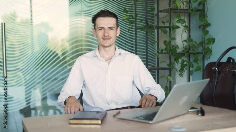 man in business attire, sitting at a desk in a modern office, talking and arguing with someone over a video call