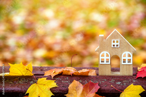 The symbol of the house stands among the fallen autumn leaves
