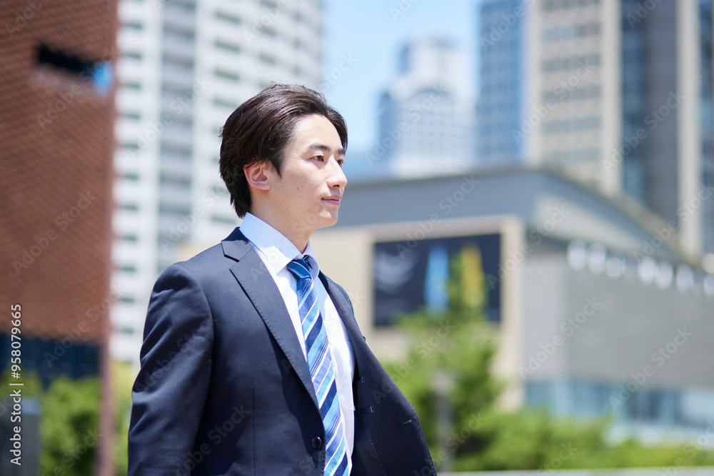 ビジネス街を歩くスーツを着た若いビジネスマン ビジネス街を歩くスーツを着た若いビジネスマン