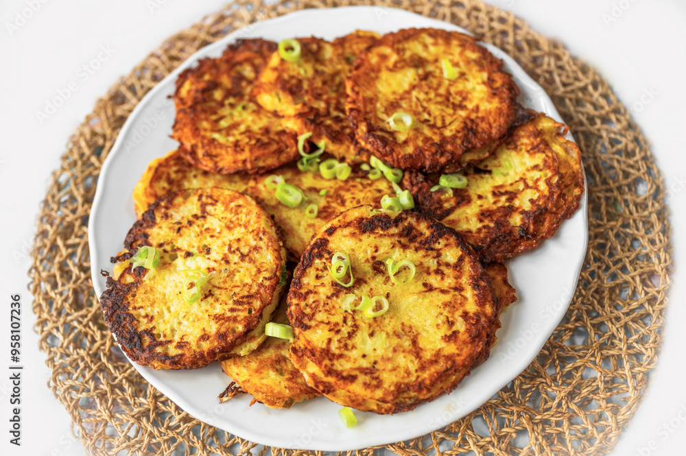 Fried salty pancake from potato, carrot and zucchini on white plate. Fried salty pancake from potato, carrot and zucchini on white plate.