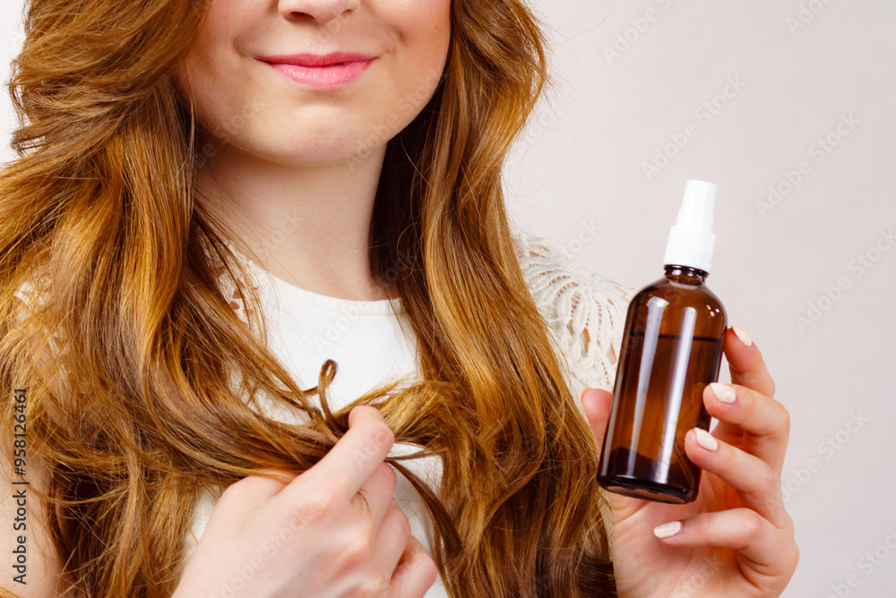 Fototapeta premium Woman applying hair cosmetic