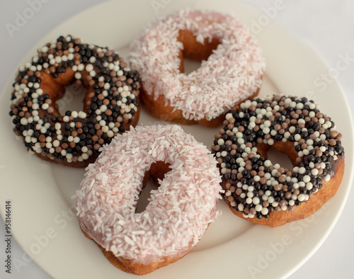 donuts with different toppings on a light background, not a healthy diet, fatty and unhealthy food, sweet pastries, donut day, Fat Thursday 