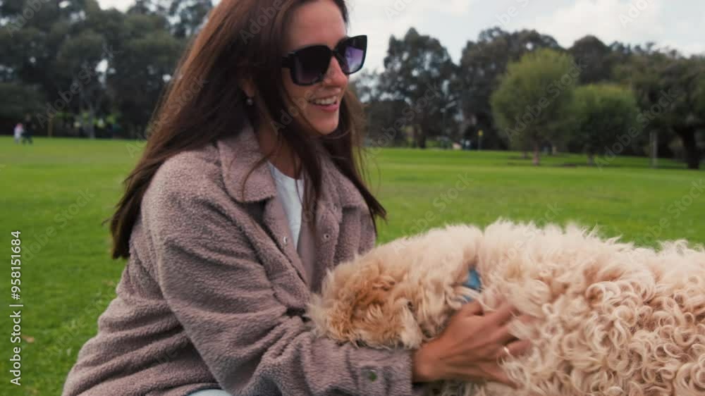 Woman joyfully interacts with her fluffy dog in a green park, sharing a playful moment under the sunny sky, highlighting their strong bond and happiness. Woman joyfully interacts with her fluffy dog in a green park, sharing a playful moment under the sunny sky, highlighting their strong bond and happiness.