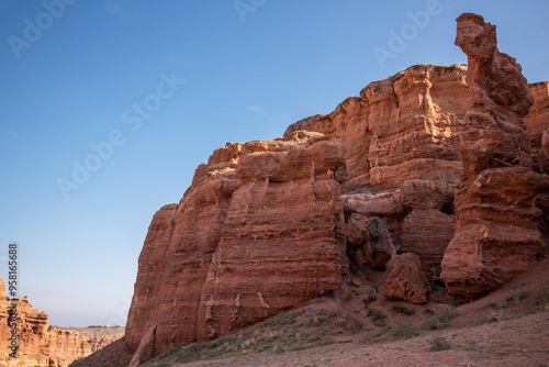 Wallpaper Mural the grandeur of towering red sandstone cliffs against a clear azure sky, a serene, untouched wilderness in late summer or early fall due to the warm lighting. Torontodigital.ca