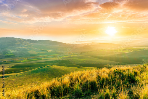 beautiful landscape in a yellow golden field in autumn or summer evening with nice rustic view of hills in countryside