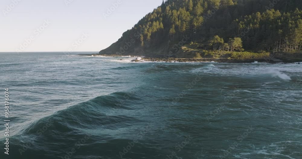 Drone dolly over serene waters as waves break and sunlight graces mountains of Captain Cook Point, Cape Cove, Oregon Coast Drone dolly over serene waters as waves break and sunlight graces mountains of Captain Cook Point, Cape Cove, Oregon Coast