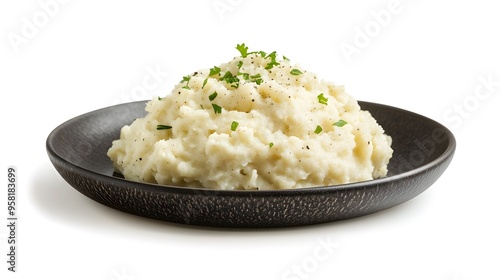 Creamy mashed potatoes with fresh herbs on a black plate