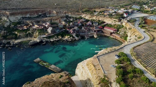 Charming 4K drone footage showcasing the colorful Popeye Village in Malta. Discover this iconic seaside village from above, a beloved tourist attraction and film set photo