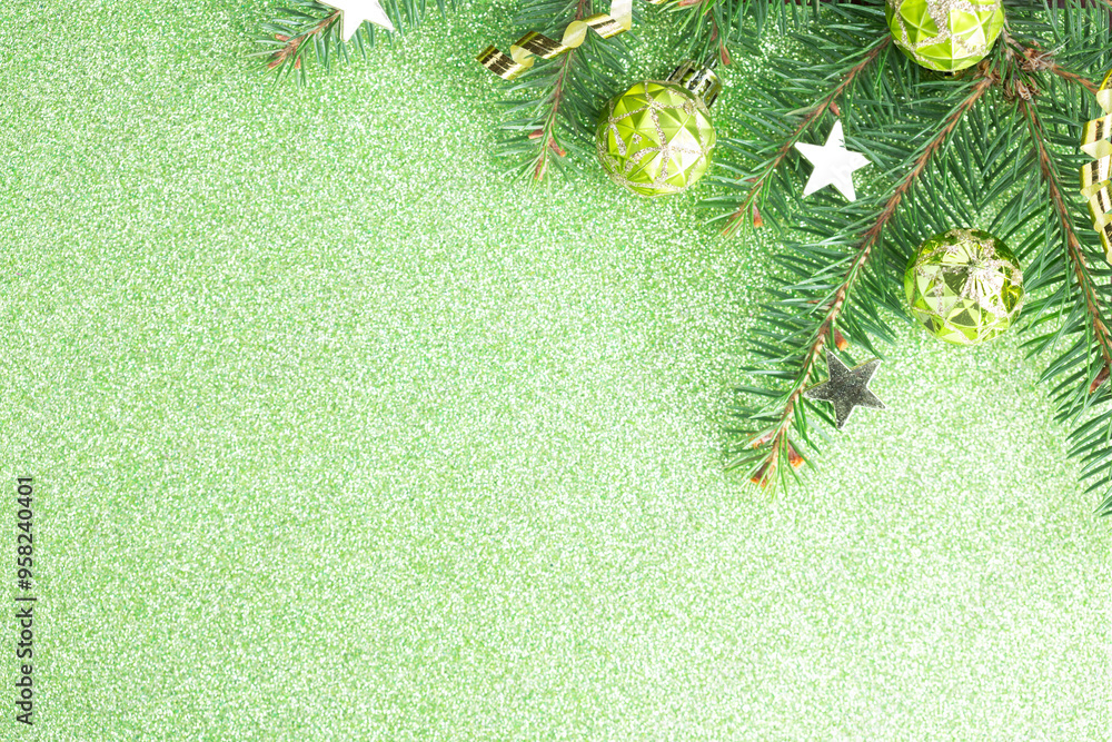 Fir branch with Christmas decoration on light green glitter background. Flat lay.