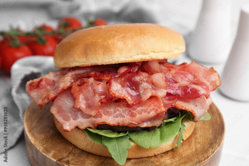Delicious burger with bacon and greens on table, closeup Delicious burger with bacon and greens on table, closeup
