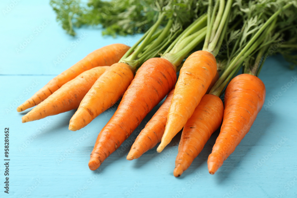 Tasty ripe juicy carrots on light blue wooden table, closeup Tasty ripe juicy carrots on light blue wooden table, closeup