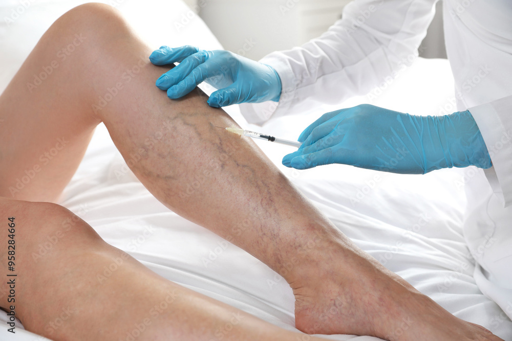Varicose veins treatment. Doctor giving injection to patient indoors, closeup Varicose veins treatment. Doctor giving injection to patient indoors, closeup