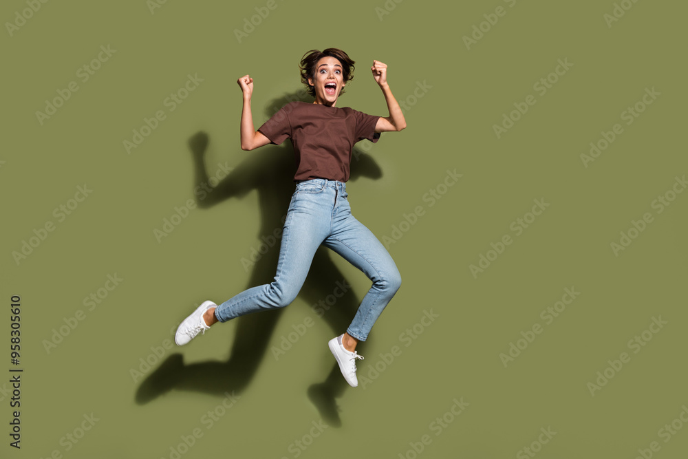 Φωτογραφία Full size photo of pretty young girl jumping raise fists celebrate excited wear