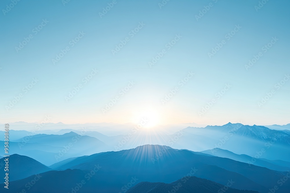 Obraz premium A serene landscape showcasing mountains under a clear blue sky with the sun rising in the background, creating a tranquil atmosphere.