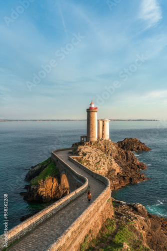 Petit Minou lighthouse and its headland, aerial view at sunset with a woman walking through the bridge