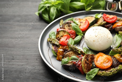 Tasty salad with grilled vegetables and mozzarella cheese on black table, closeup. Space for text