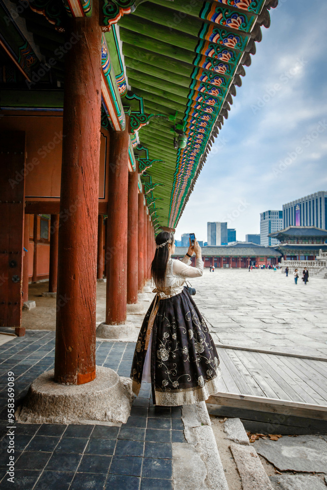 Tourists in national clothes walk in Gyeongbokgung Palace