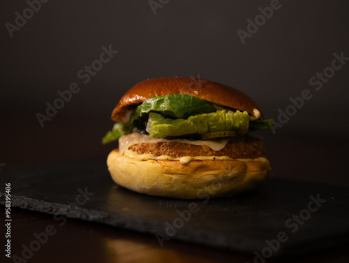 Chiken cheese burger with bacon on black background photo