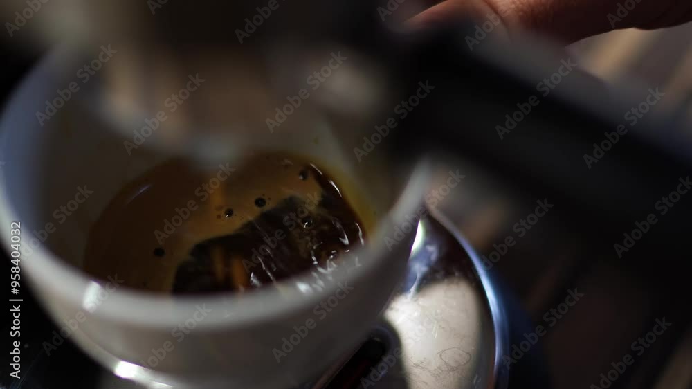 Black coffee dripping from a coffee maker horn into a cup on a tray. High quality 4k footage Black coffee dripping from a coffee maker horn into a cup on a tray. High quality 4k footage