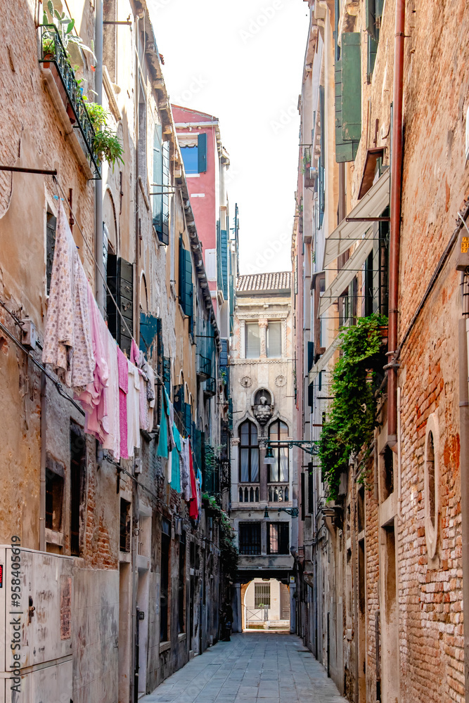 A stunningly picturesque alley in the heart of Venice, showcasing laundry hanging among beautiful historic buildings A stunningly picturesque alley in the heart of Venice, showcasing laundry hanging among beautiful historic buildings