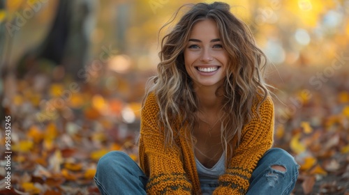 beautiful woman in her thirties, laughing and sitting on ground amidst colorful autumn leaves wearing jeans, brown boots, yellow cardigan sweater, green knitwear, smiling at camera, forest background